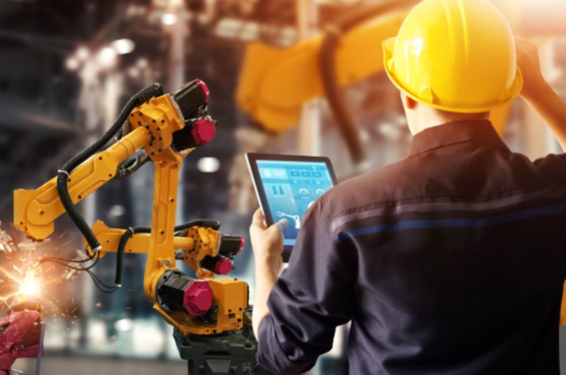 Ingeniero supervisando un brazo robótico industrial